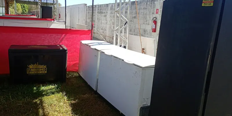 Freezer horizontal e equipamento vertical em barraca de evento
